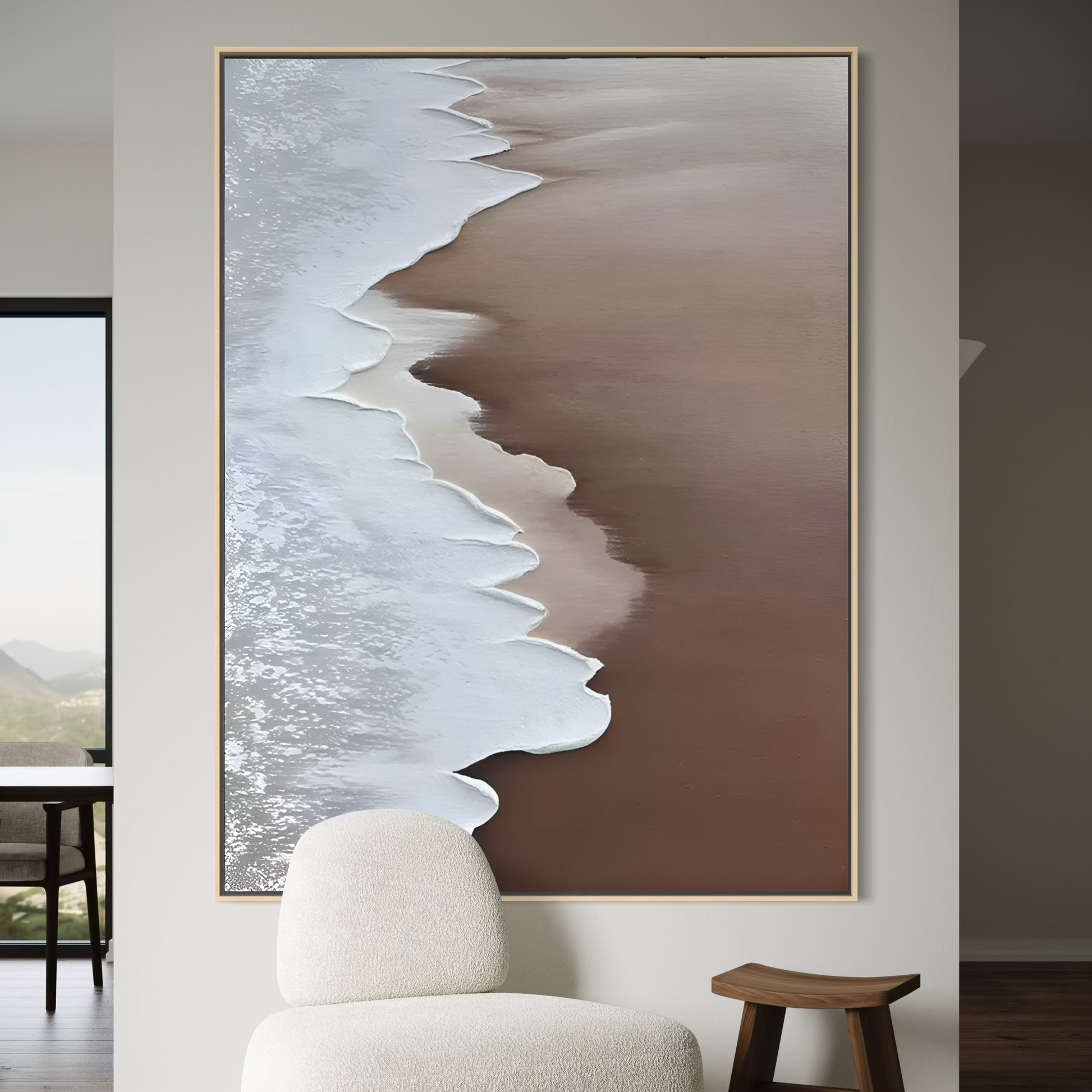 Brown wave abstract art piece on a wall above a white armchair and wooden stool.